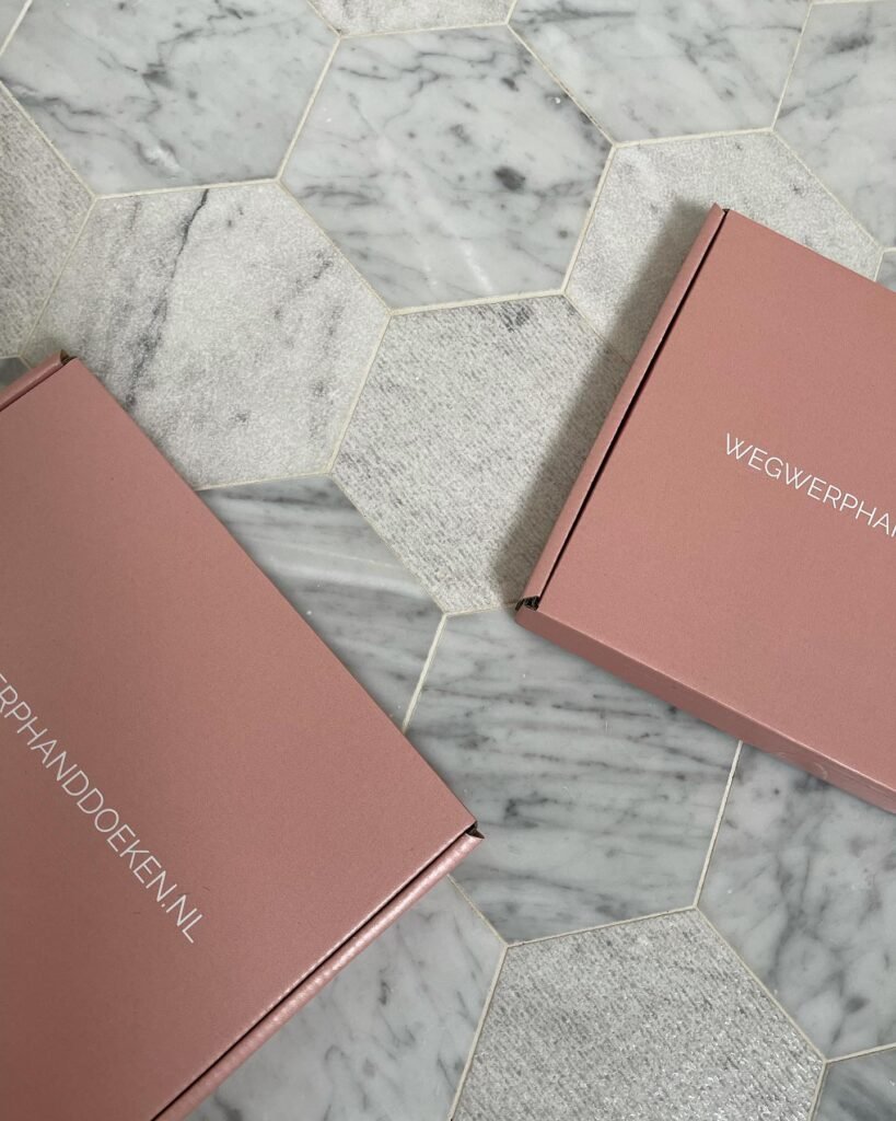 Roze Wegwerphanddoeken.nl verpakkingen op marmeren tegelvloer